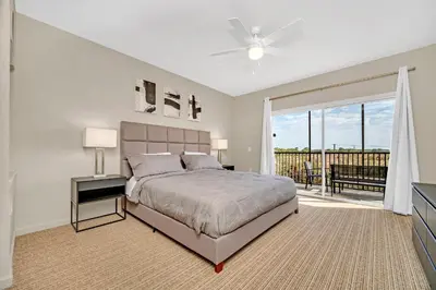 a bedroom with a large bed and a balcony at Condo w Pool, Games Room - Pet Friendly in Orlando