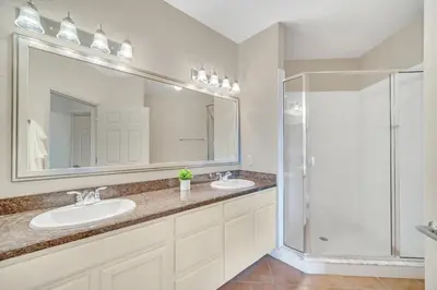 a bathroom with two sinks and a shower at Condo w Pool, Games Room - Pet Friendly in Orlando