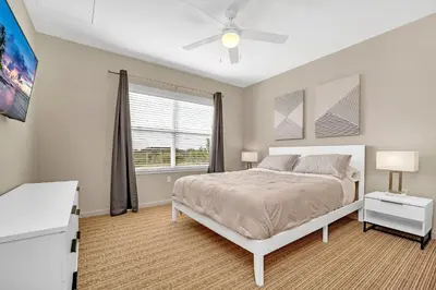 a bedroom with a bed with a ceiling fan and a window at Condo w Pool, Games Room - Pet Friendly in Orlando