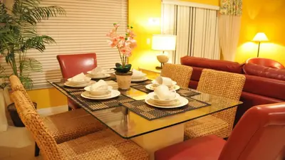 a dining room with a table with chairs and a couch at Coral Cay - 4 Bed 3 Baths Townhome in Kissimmee