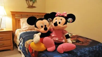 two mickeys are sitting on a bed at Coral Cay - 4 Bed 3 Baths Townhome in Kissimmee