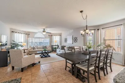 a dining room and living room with a table and chairs at LOVE AT FIRST SIGHT! NEW Disney Home, Sleeps 6, Pool, Patio, NO Steps, LOW Rates! in Kissimmee