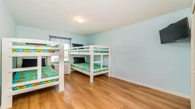 two bunk beds in a room with a flat screen tv at Shvcc1 - Crystal Cove #1 - 7 Bed 45 Baths Villa in Kissimmee