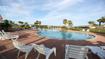 a swimming pool with white chairs around it at Shvcc1 - Crystal Cove #1 - 7 Bed 45 Baths Villa in Kissimmee