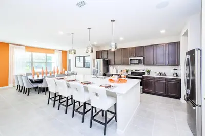 a kitchen with a large white island with bar stools at 15BR Mansion Home with Pool & Hot Tub-near Disney in Kissimmee