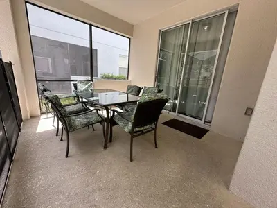 a dining room with a table and chairs and windows at Paradise Palms Resort - 6 Bed 5 Baths Villa in Kissimmee