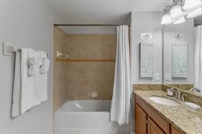 a bathroom with a tub and a sink and a shower at New listing 5 mi from Disney,Free Arcades, HeatedPool & Water park in Kissimmee
