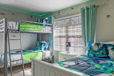 a bedroom with two bunk beds and a window at New listing 5 mi from Disney,Free Arcades, HeatedPool & Water park in Kissimmee