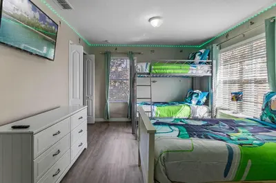 a bedroom with a bed and a bunk bed at New listing 5 mi from Disney,Free Arcades, HeatedPool & Water park in Kissimmee