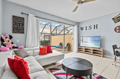 a living room with a white couch and a tv at The Wish House, just miles from Disney World in Orlando