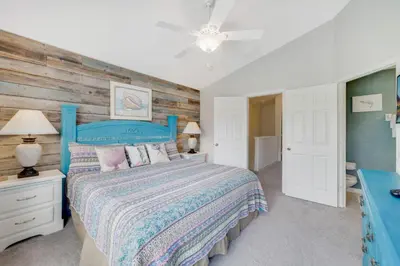 a bedroom with a blue bed and a wooden wall at Windsor Hills Townhome in Orlando