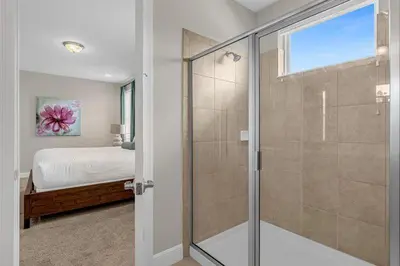 a bedroom with a bed and a glass shower at 541 Villa- 7BD Dream Home - Private PoolSpa in Orlando