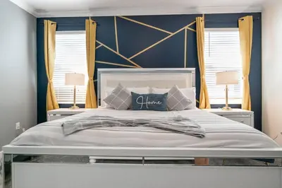 a bedroom with a large white bed with two lamps at Luxury 9BR Villa @ Storey Lake Resort Near Disney in Kissimmee