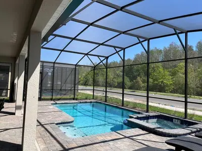 an indoor swimming pool in a glass house at Luxury 9BR Villa @ Storey Lake Resort Near Disney in Kissimmee