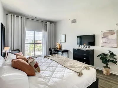 a white bedroom with a large bed and a window at Pet friendly in Orlando area near Disney and ESPN Center in Orlando