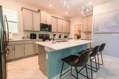 a kitchen with a large island with two bar stools at Modern Adventure Home near to Disney in Kissimmee