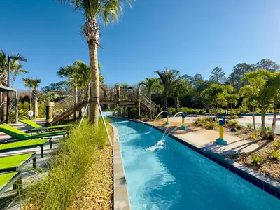 a lazy river at a theme park with a palm tree at 6BR Disney Oasis with Pool, Game Room and Resort in Kissimmee
