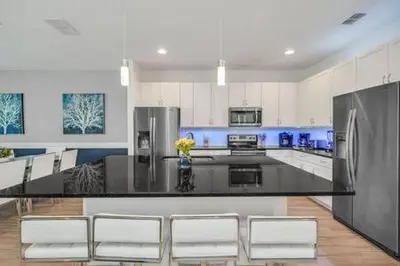 a kitchen with a black counter and white cabinets at Serene Sunsets Villa - E04 in Kissimmee