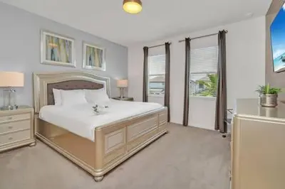 a bedroom with a large white bed and windows at Serene Sunsets Villa - E04 in Kissimmee
