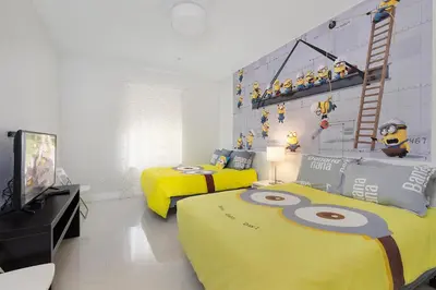 a room with two beds and a tv and a room with a room with at One in a Minion #102 in Orlando