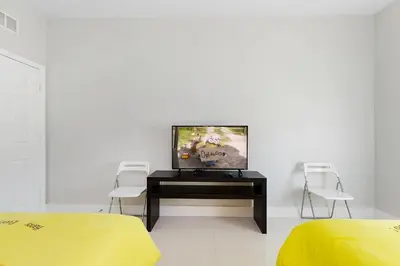 a room with a tv on a table with two chairs at One in a Minion #102 in Orlando