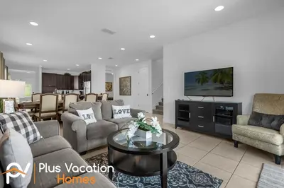 a living room with a couch and a tv at 7594 Oasis 8BD Villa- poolspa in Orlando