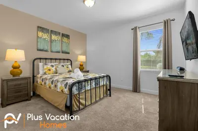 a bedroom with a bed and a dresser and a window at 7594 Oasis 8BD Villa- poolspa in Orlando