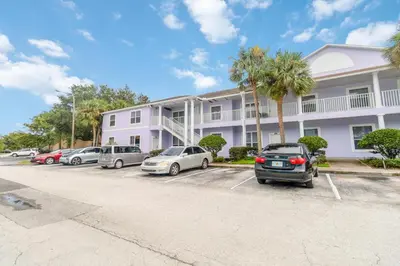 a parking lot in front of a building with cars parked at Huge Screened Patio That Overlooks Lake Buck, Near Famous Attractions!! in Orlando