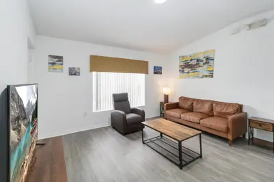 a living room with a couch and a table at Huge Screened Patio That Overlooks Lake Buck, Near Famous Attractions!! in Orlando