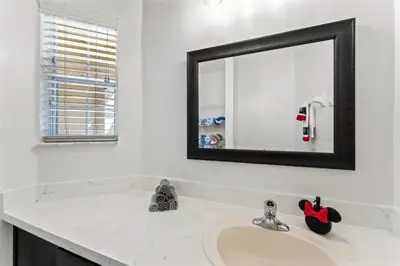 a bathroom with a sink and a mirror at *PRIVATE POOL* Disney10min - Magical Mickey themed home in Kissimmee