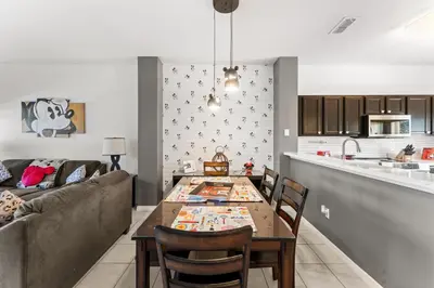 a kitchen and living room with a table and a couch at *PRIVATE POOL* Disney10min - Magical Mickey themed home in Kissimmee