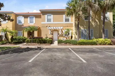 a large house with palm trees in a parking lot at *PRIVATE POOL* Disney10min - Magical Mickey themed home in Kissimmee