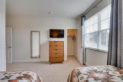 a bedroom with a bed and a dresser and a window at Townhome with Lanai about 9 Mi to Disney! in Orlando