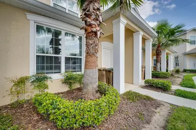a palm tree in front of a house at Townhome with Lanai about 9 Mi to Disney! in Orlando