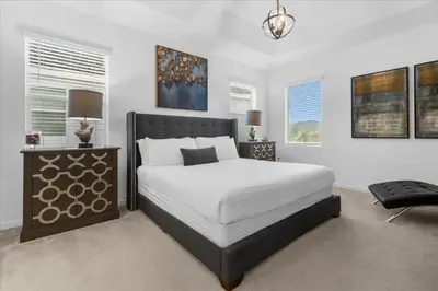 a bedroom with a large bed and a chair at 5BR Family Home with Pool & Hot Tub Near Disney in Kissimmee