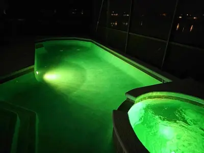 a green bath tub with a light in it at night at 6 Bedroom Luxury Pool Home, Ensuite Bathrooms in Kissimmee