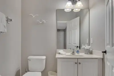 a bathroom with a toilet and a sink and a mirror at 6 Bedroom Luxury Pool Home, Ensuite Bathrooms in Kissimmee