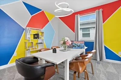 a dining room with a colorful wall with a table and chairs at Modern Resort House Pool Wi-Fi Minutes to Disney in Kissimmee