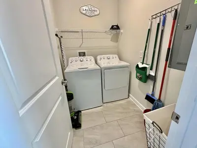 a small laundry room with a washer and dryer at Amazing 6br w pvt pool game room near Disney in Kissimmee
