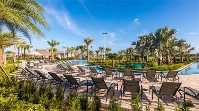 a row of chairs next to a pool at a resort at Amazing 6br w pvt pool game room near Disney in Kissimmee