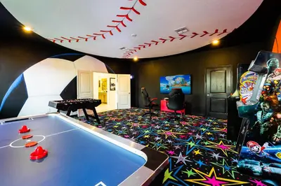 a living room with a pool table and a game room at Amazing 8br w pool theater game room by Disney in Kissimmee