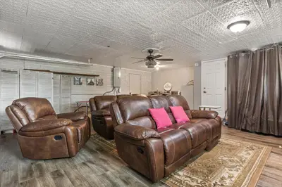 a living room with brown leather furniture and pink pillows at Luxury Home, Workspace, Movie Room and BBQ in Kissimmee