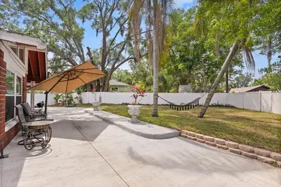a patio with a table and an umbrella at Luxury Home, Workspace, Movie Room and BBQ in Kissimmee