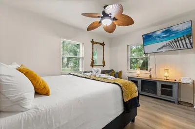 a bedroom with a bed and a ceiling fan at Luxury Home, Workspace, Movie Room and BBQ in Kissimmee