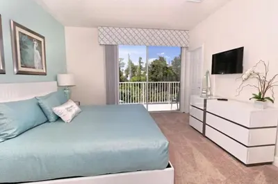 a bedroom with a blue bed and a balcony at Serenity 3 Bed 3 Bath Townhome With Pool, Private Balcony, Clubhouse, Communal Pool, Conservation View, Disney 15 Mins By Orlando Holiday Rental, in Orlando
