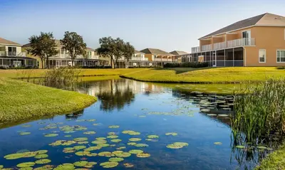 a river with lily pads in front of a building at Serenity 3 Bed 3 Bath Townhome With Pool, Private Balcony, Clubhouse, Communal Pool, Conservation View, Disney 15 Mins By Orlando Holiday Rental, in Orlando