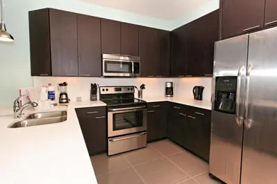 a kitchen with wooden cabinets and stainless steel appliances at Serenity 3 Bed 3 Bath Townhome With Pool, Private Balcony, Clubhouse, Communal Pool, Conservation View, Disney 15 Mins By Orlando Holiday Rental, in Orlando