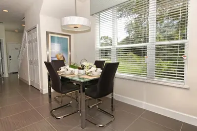 a dining room with a table and chairs and a window at Serenity 3 Bed 3 Bath Townhome With Pool, Private Balcony, Clubhouse, Communal Pool, Conservation View, Disney 15 Mins By Orlando Holiday Rental, in Orlando
