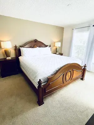 a bedroom with a large bed with white sheets and a window at Lakeside Community, Pools, And More! in Kissimmee
