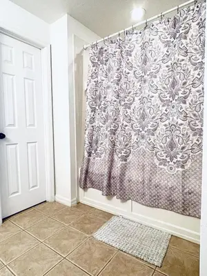 a shower curtain in a bathroom with a tile floor at Lakeside Community, Pools, And More! in Kissimmee